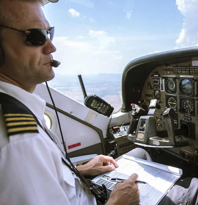Picture of a pilot sitting in the cockpit of an airplain. 