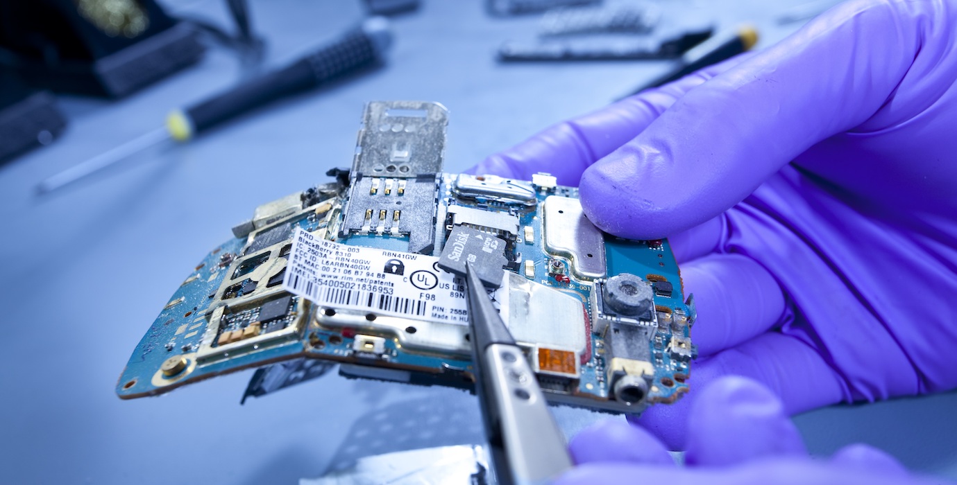 Employee removing a SIM card for investigation at the netherlands forensic institute. 