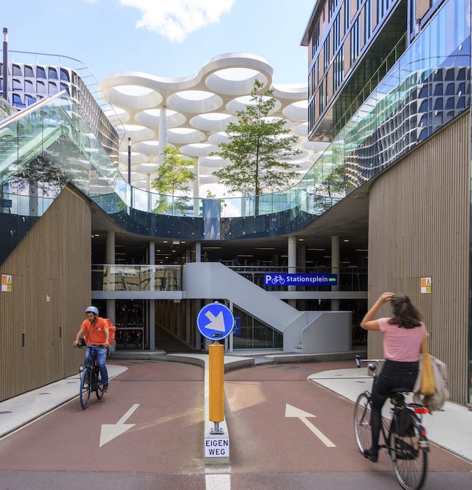 People cycling in the bicycle storage at the train station in Utrecht. 