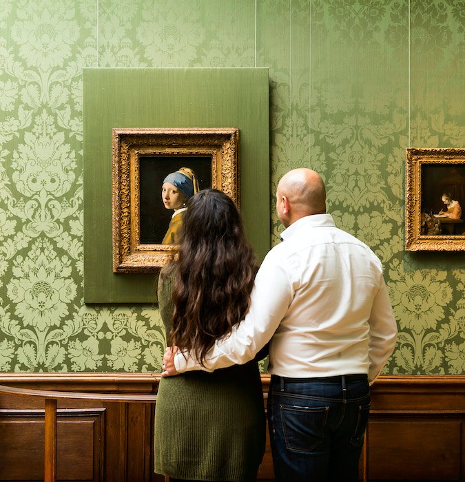 Couple looking at the painting of Vermeer, the girl with the pearl earring. 