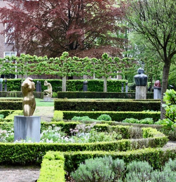 A Garden with statues and vegetation. 