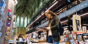 A woman reading a book in the bookstore. 