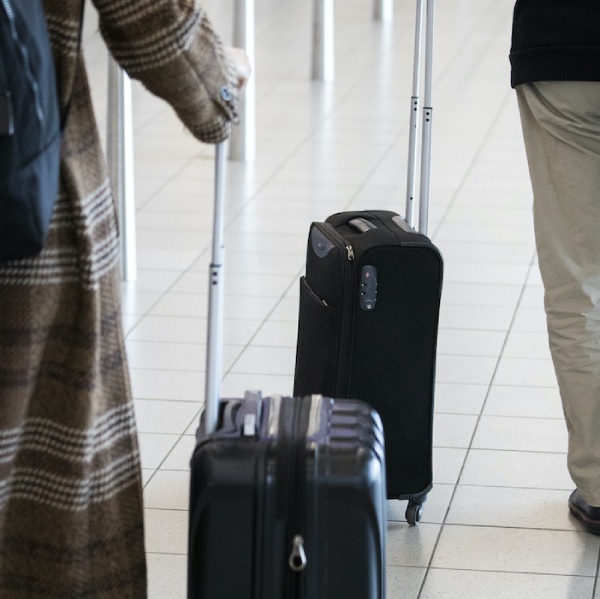 Applying from abroad - two people with a suitcase on the airport