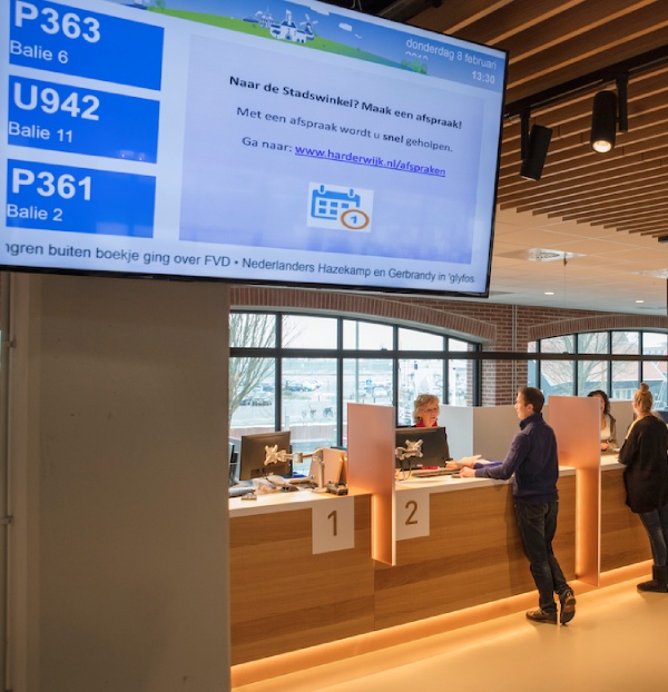 People waiting at the desk of the municipality office. 