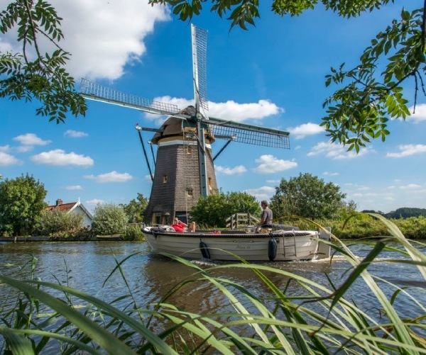 Dutch landscape with a wind mill on a sunny day. 