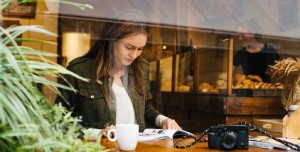 Woman reading a magazine in a coffee bar. 