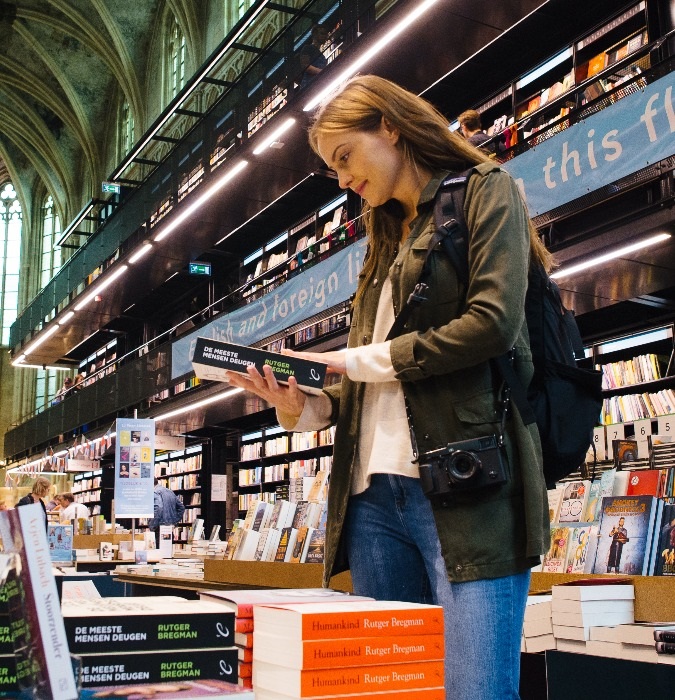 Woman reading a book in a bookstore 
