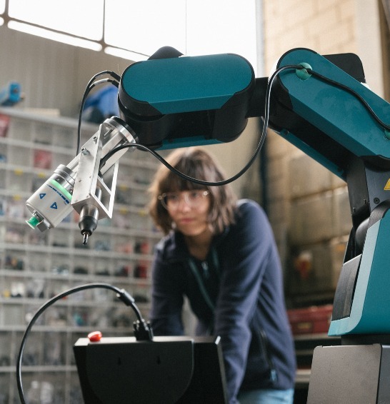 Engineer working on a robot arm with device 